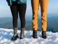 Dwie pary solidnych butów trekkingowych, niczym nowoczesne walonki, stoją na śniegu.