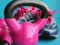 Różowe kettlebelle i buty sportowe marki Adidas gotowe do treningu.