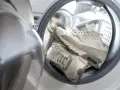 Białe trampki czekają na pranie w pralce. Czas przywrócić im dawny blask!
