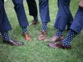 Elegancki granatowy garnitur i brązowe buty, a do tego zabawne skarpetki w kropki. Idealny zestaw na letnie wesele.