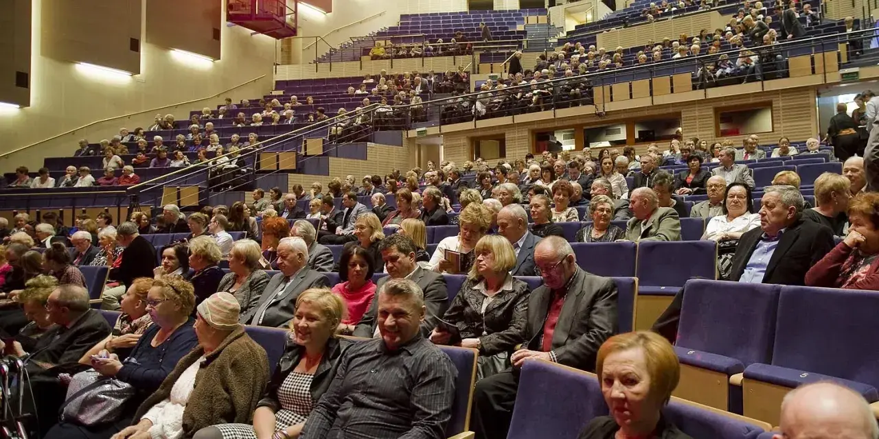 Widownia filharmonii, ludzie w eleganckich strojach. Zastanawiasz się, jak się ubrać do filharmonii? Tutaj znajdziesz inspiracje.