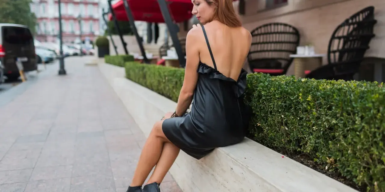 Kobieta w czarnej sukience i sandałach na obcasie, idealne buty do czarnej sukienki na letnie wieczory.