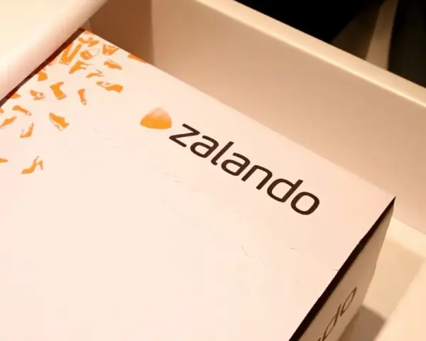 Pudełko z logo Zalando, ozdobione pomarańczowymi sylwetkami butów. Ciesz się zakupami z zalando lounge darmowa dostawa!
