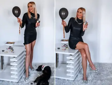 Elegancka czarna sukienka, idealna na 18. Urodziny. W dłoni czarny balon i kieliszek szampana. Na podłodze piesek.