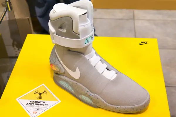 Nike Mag, najdroższe buty na świecie, z technologią "Magnetic Anti Gravity", prezentowane na żółtym tle.