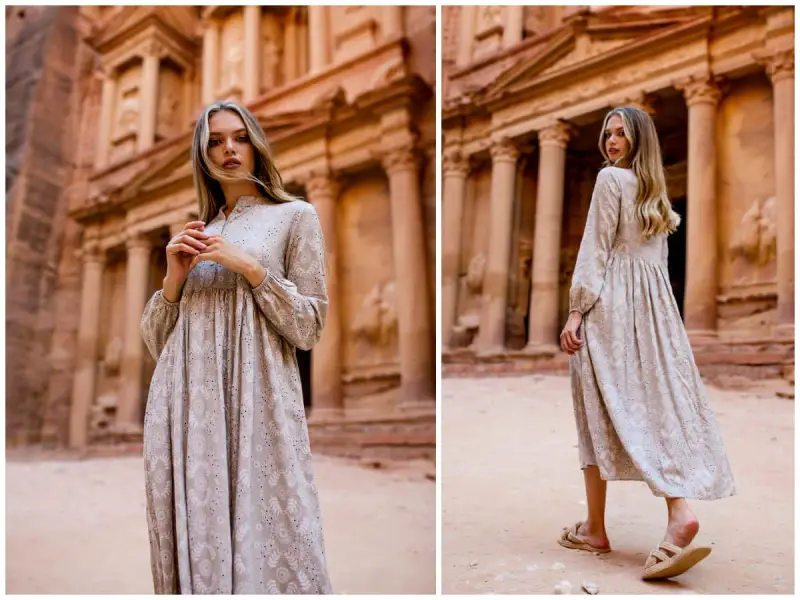 Kobieta w zwiewnej sukience w stylu empire na tle starożytnej budowli.